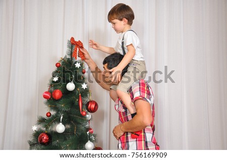 Young father with decorating Christmas tree with his son. Family together for holidays