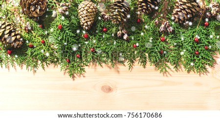 Christmas background with fir tree and pine cones on wooden board