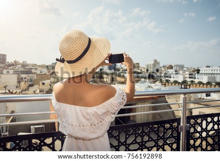 Girl photographing the city. On the roof. Travel, rest. Tunisia.