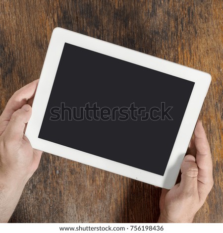 Digital tablet computer with isolated screen in male hands close up