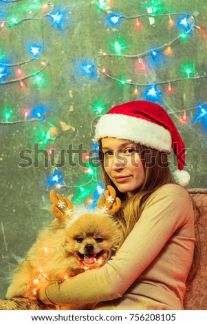 A girl in a Christmas hat with a dog Pomeranian Pomeranian
