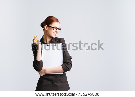 A girl secretary wearing glasses and a business suit is holding a file