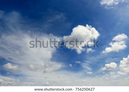 White cumulus clouds against the background of an epic dark blue sky.