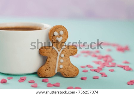 loving gingerbread man stands near a white mug, copy space
