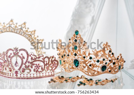 Royal luxury gold and silver crowns decorated with precious stones. Diamond tiaras with gemstones for prom and wedding. Selective focus.