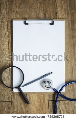 Healthy background concept. Business checking. Empty paper notepad on wood table with pen, magnifier and stethoscope. Picture for add text message. Backdrop for design art work.