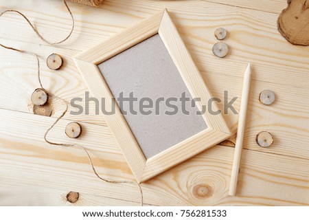 Light wooden frame on a wooden background. Flat lay, top view photo mockup.