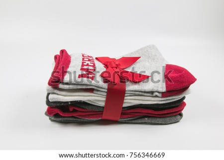 Pack of socks wrapped with a red ribbon with title "Merry". Gift for Christmas. White background without shadow