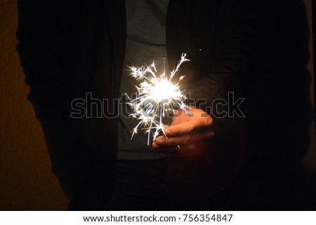 Hold a burning sparkler in your hand during the night