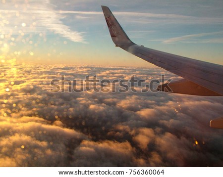 aerial view from a plane over the clouds with sunlight