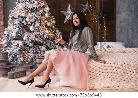 Girl is sitting on the bed and smiling. Christmas feeling. Christmas party.