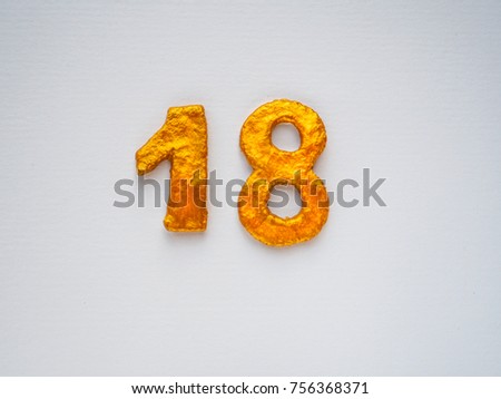 Sign 18 gold color on a light background.