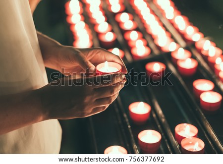 Woman holding candle near altar in church. Royalty-Free Stock Photo #756377692