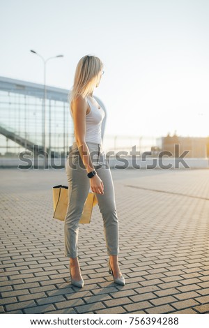 Business woman wearing sunglasses in gray pants