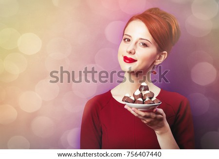 photo of beautiful young woman with plate full of chocolate candies on the wonderful purple background
