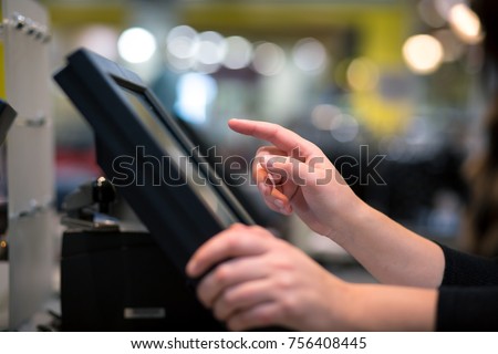 Young woman hand doing process payment on a touchscreen cash register, finance concept