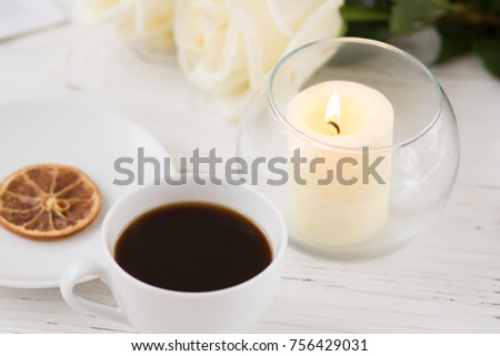 Coffee for breakfast or lunch with decorations, candles and flowers. white roses on the table and cup of coffee