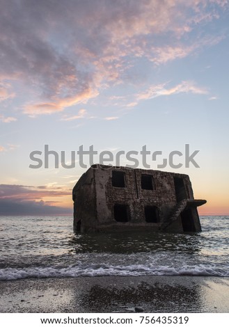 Sunset over ruins of a military barricades of the Soviet Union in the Baltic Sea, Latvia