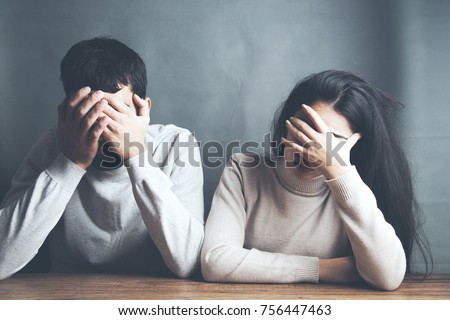 sad young couple sitting in table on dark background Royalty-Free Stock Photo #756447463