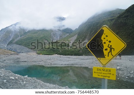 Warning signage of beware of falling rocks in New Zealand lake