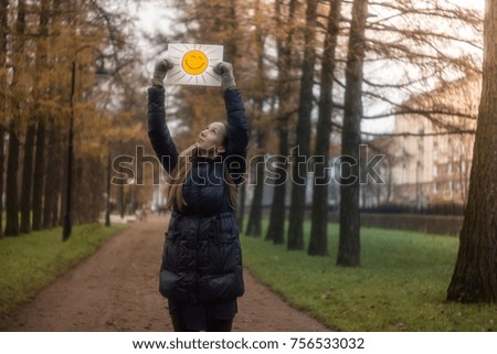 girl holding a drawing of the sun