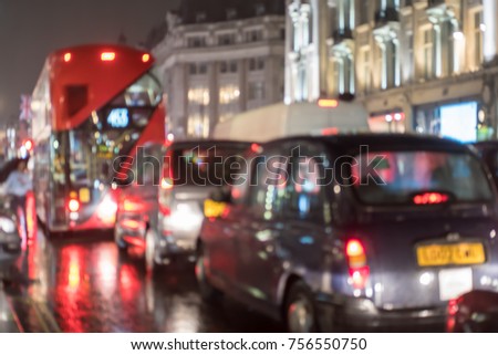 Blurred image bokeh of cars and red bus on Oxford Street, with people walking on the street