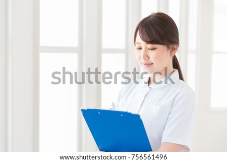 Young attractive asian nurse of the smile,interview sheet
