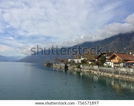 Beautiful green lake with inverted images against blue and white sky, Brienz, Switzerland, Europe