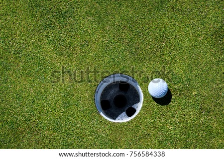 Golf ball on the green next to the hole, waiting to be tapped in
 Royalty-Free Stock Photo #756584338