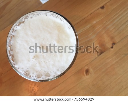Top view of beer in glass on wooden table with copy space