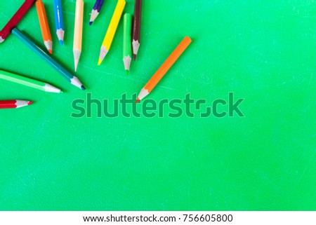 Colored Pencils for School or Professional Use on rough texture green table with copy space
