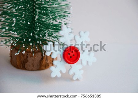 Merry Christmas greeting card with snowflake near christmas tree on white background in macro.