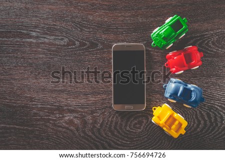 Four cars model and smartphone on wooden background with copyspace. concept of car rental, auto car insurance and traveling