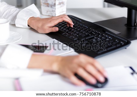 women's hands are typing on  laptop's keyboard.