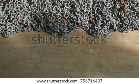 Pile of rusty chain on wooden texture.