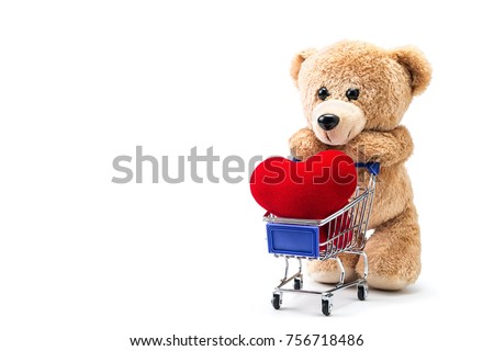 A photo of teddy bear with heart shaped pillow in a cart on isolate white background with space for copy text