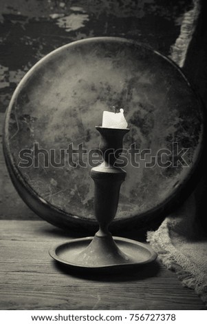 Old candle on a wooden background. Toned.