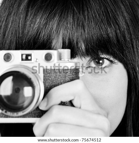 Close up of young girl in black and white with vintage camera