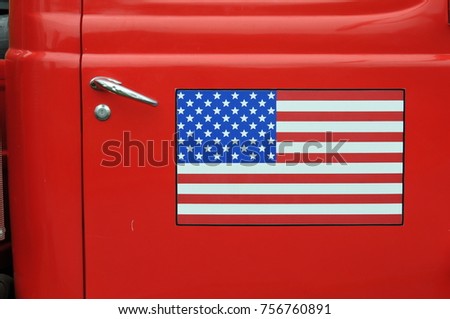 American flag on the door of a vintage red truck, background of Usa flag on red car door. Abstract background flag of America, sticker on car.