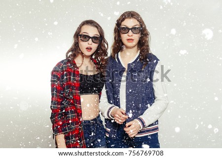 winter, christmas, holiday, space, xmas, technologies, emotions, lifestyle, people, teens and friendship concept - Two attractive smiling girl in a 3d-glasses slightly tilted to the right. over snow