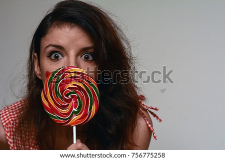 Female model enjoying a colorfull lollipop