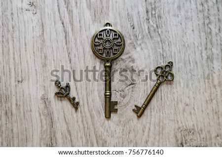 Composition, several old bronze keys on a wooden background.