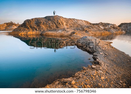 Reflection of unidentified photographer standing on the small rock island. 