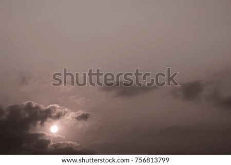 Gray fluffy clouds in the morning sky with sunlight and sun