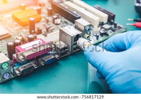 The abstract image of the technician connecting LAN cable (RJ45) the the computer mainboard. The concept of internet, connecting, communication, electronic and internet of things.