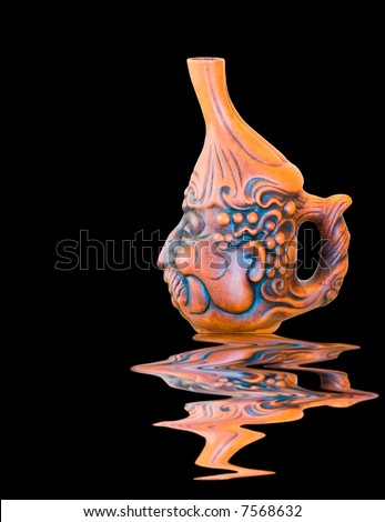 Clay jug on black background with water reflection