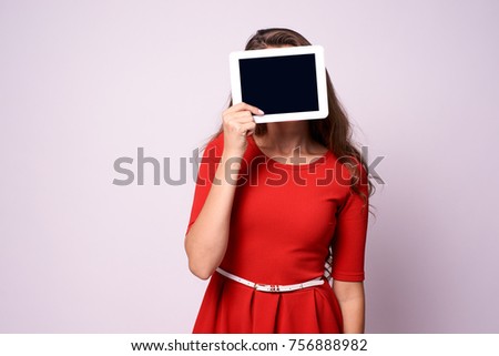 Girl with tablet. Modern technologies. Red dress.
