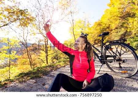Young woman taking a selfie with bicycle