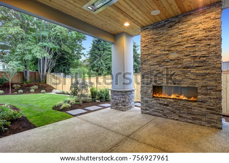 Outside Patio features natural wood plank ceiling, concrete floor and oversized stone fireplace overlooking a beautiful expansive yard.  Northwest, USA