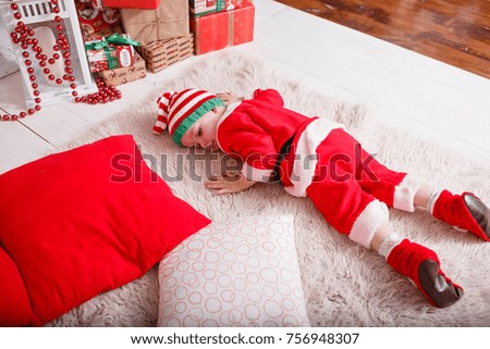 child in costume gnome by the fireplace and Christmas tree